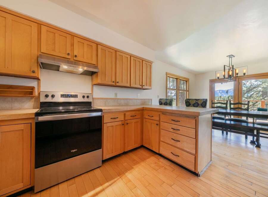 This stunning kitchen boasts beautiful wooden cabinetry and modern stainless steel appliances, creating a warm and inviting atmosphere.