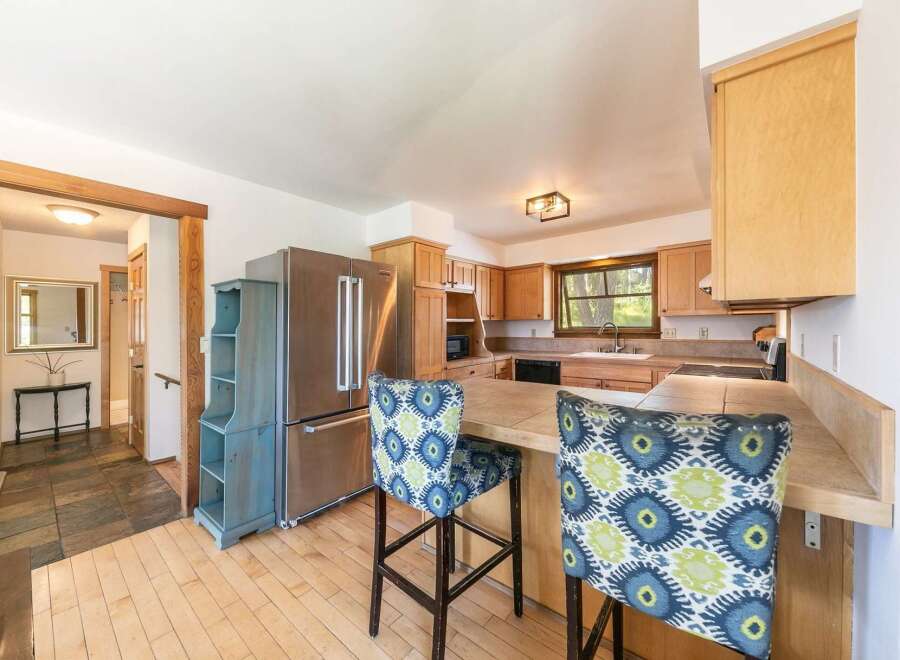 Step into this inviting kitchen, featuring a stainless steel refrigerator and ample cabinet space.