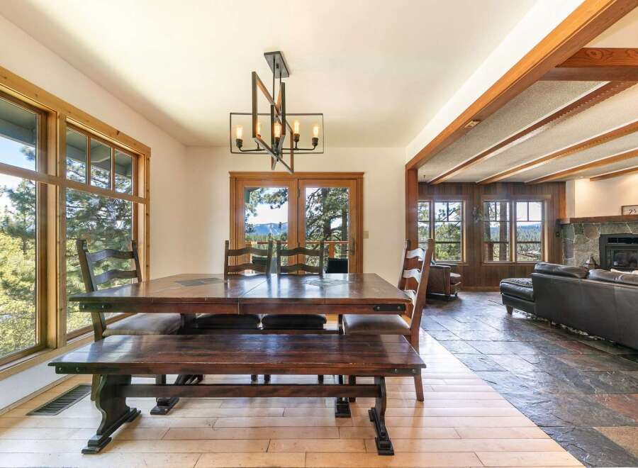 This stunning property features a spacious dining area with a beautiful wooden table and bench, perfect for family gatherings.
