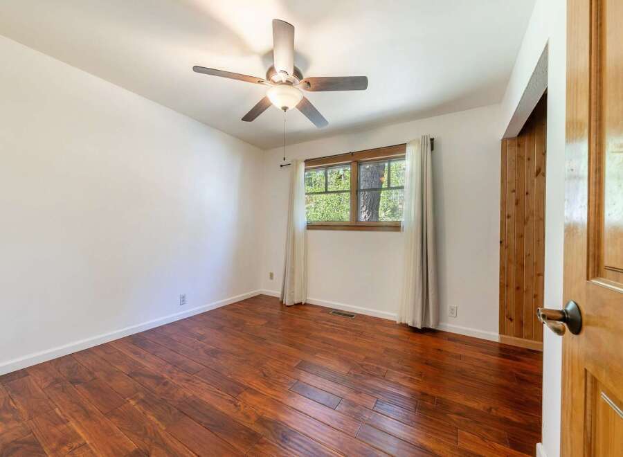 Step into this inviting room featuring beautiful hardwood floors and a stylish ceiling fan.