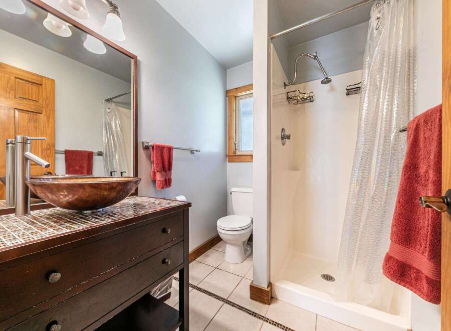 This stunning bathroom features a unique vessel sink and a stylish vanity, creating a focal point of elegance.