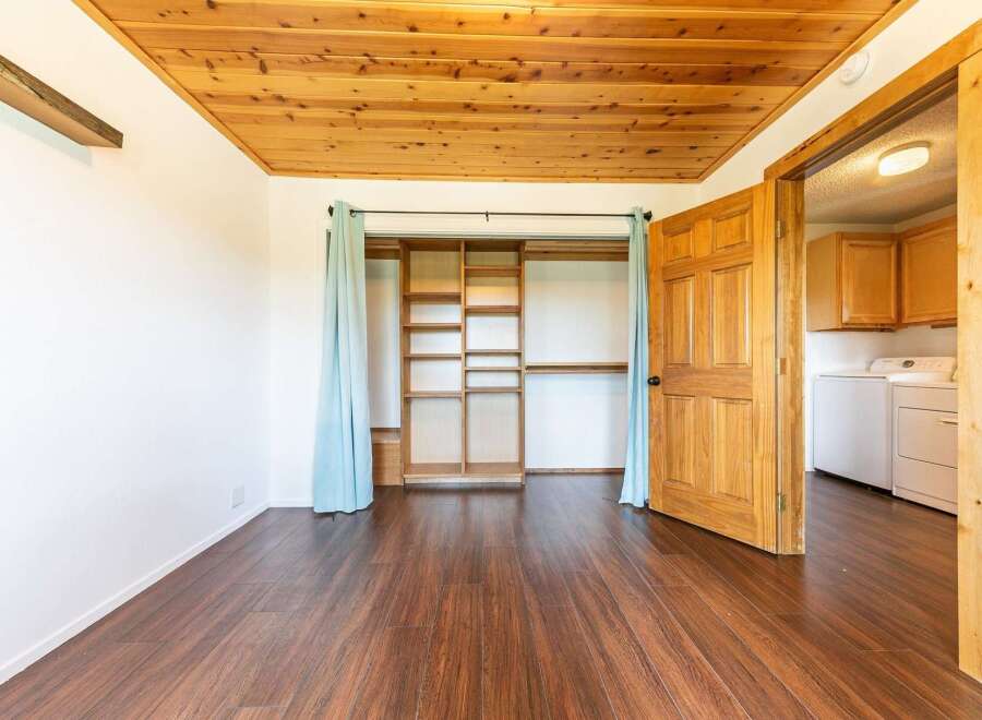 Step into this inviting space featuring a warm wooden ceiling and rich hardwood floors.