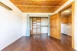 Step into this inviting space featuring a warm wooden ceiling and rich hardwood floors.