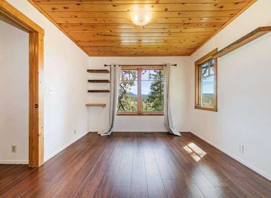 This stunning property boasts a warm and inviting interior with beautiful wood flooring and a charming wooden ceiling.