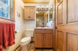 This charming bathroom features a warm, inviting ambiance with its wooden cabinetry and trim.