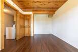 Discover the charm of this inviting space, featuring a warm wooden ceiling and rich, dark wood flooring.