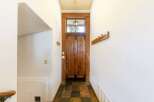 Step into this inviting entryway, showcasing a stunning wooden door and a unique slate tile floor.