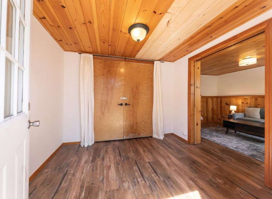 Step into this inviting space with stunning wood flooring and a warm, natural wood ceiling.
