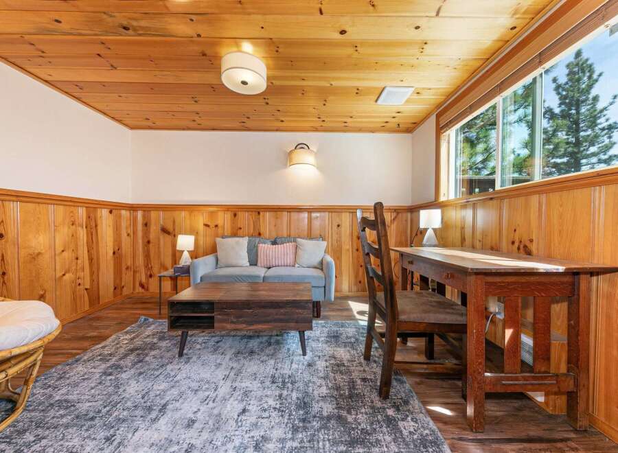 This cozy living space features a warm, inviting atmosphere with its wood-paneled walls and ceiling.