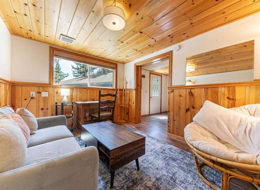 Step into this cozy cabin retreat, featuring a warm and inviting interior with wood paneling and a charming ambiance.