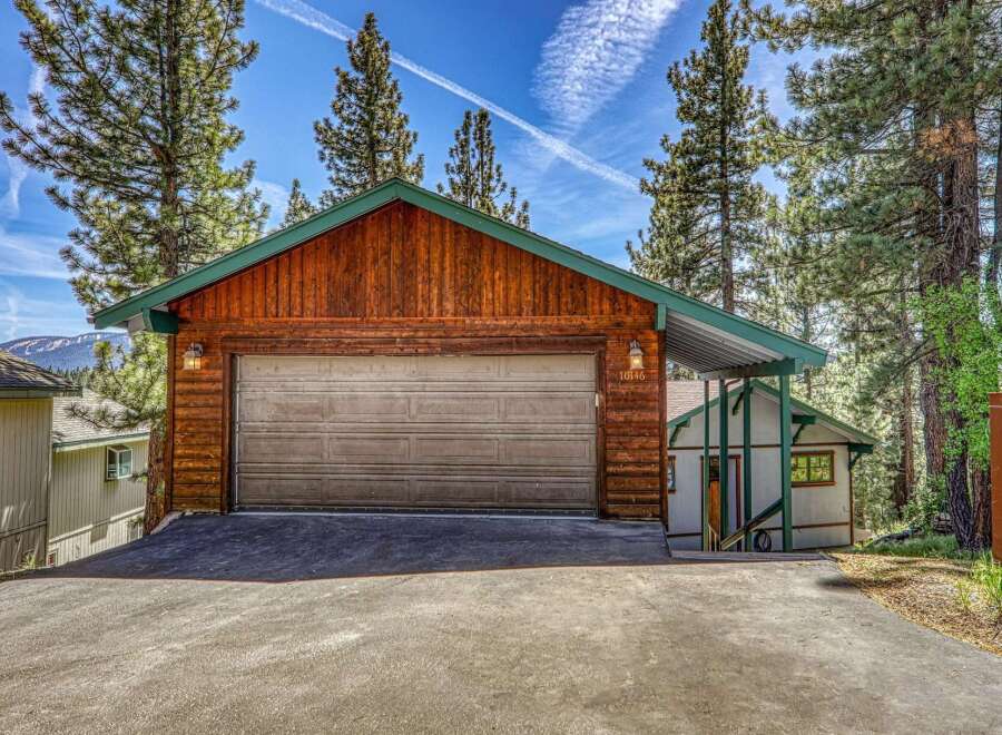 This charming property boasts a rustic exterior with a wooden garage and a welcoming carport.