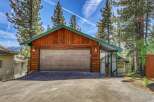 This charming property boasts a rustic exterior with a wooden garage and a welcoming carport.