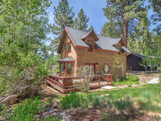 Nestled amidst lush greenery, this charming wooden cabin offers a serene retreat.