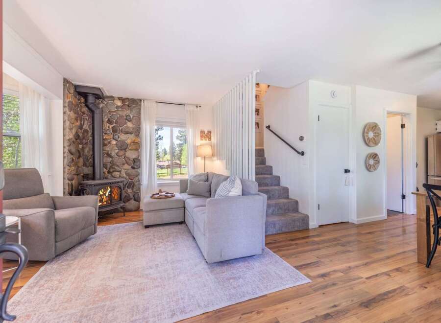 Step into this inviting living space, featuring a cozy stone fireplace and a comfortable sectional sofa.
