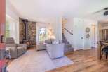 Step into this inviting living space, featuring a cozy stone fireplace and a comfortable sectional sofa.