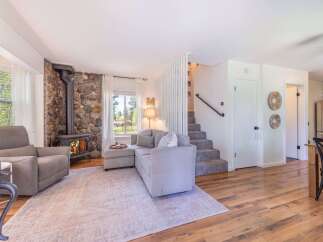 Step into this inviting living space, featuring a cozy stone fireplace and a comfortable sectional sofa.