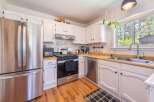 Step into this charming kitchen, featuring stainless steel appliances and ample counter space.