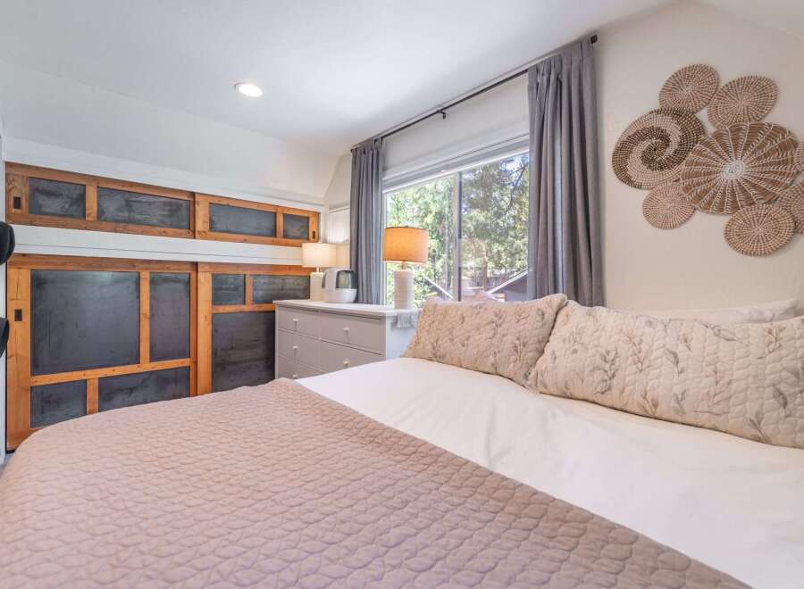 Step into this cozy bedroom, featuring a comfortable bed with soft pillows and a stylish quilt.