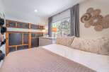 Step into this cozy bedroom, featuring a comfortable bed with soft pillows and a stylish quilt.
