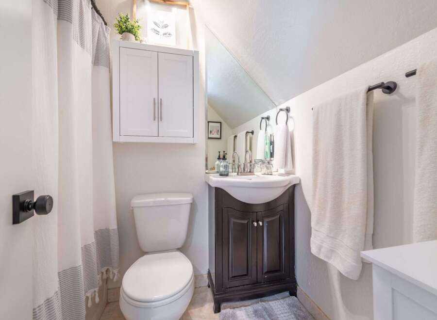 This charming bathroom features a stylish vanity with a dark wood finish, offering ample storage and a touch of elegance.