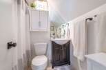 This charming bathroom features a stylish vanity with a dark wood finish, offering ample storage and a touch of elegance.