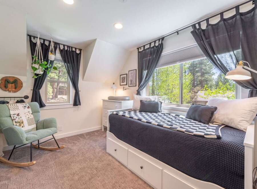 This charming bedroom offers a cozy retreat with its inviting design and ample natural light.