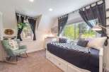 This charming bedroom offers a cozy retreat with its inviting design and ample natural light.
