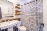 This charming bathroom features a modern design with a pedestal sink and a stylish shower curtain.
