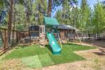Enjoy outdoor fun in this property's backyard, featuring a playground with a slide and swings.
