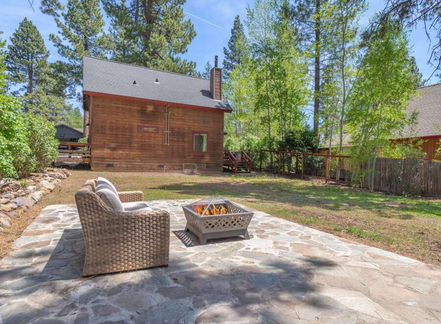 Enjoy the tranquility of this stunning property featuring a cozy outdoor seating area and a charming fire pit, perfect for entertaining or relaxing.