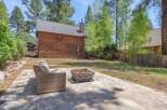 Enjoy the tranquility of this stunning property featuring a cozy outdoor seating area and a charming fire pit, perfect for entertaining or relaxing.