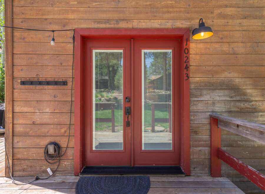 This charming property features a welcoming entrance with a vibrant red door and a classic design.