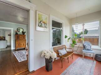 Step into this charming home and discover a sun-drenched porch, perfect for relaxing and enjoying the day.
