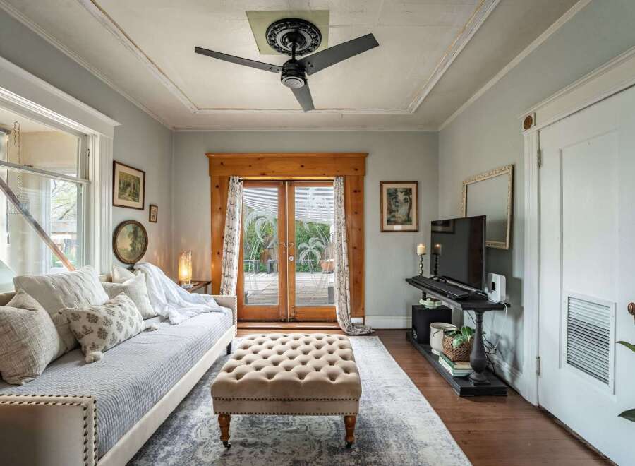 Step into this charming living space, featuring a cozy daybed and a stylish tufted ottoman.