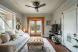 Step into this charming living space, featuring a cozy daybed and a stylish tufted ottoman.