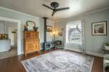 Step into this charming living space, featuring a cozy wood-burning stove and a beautiful antique cabinet.