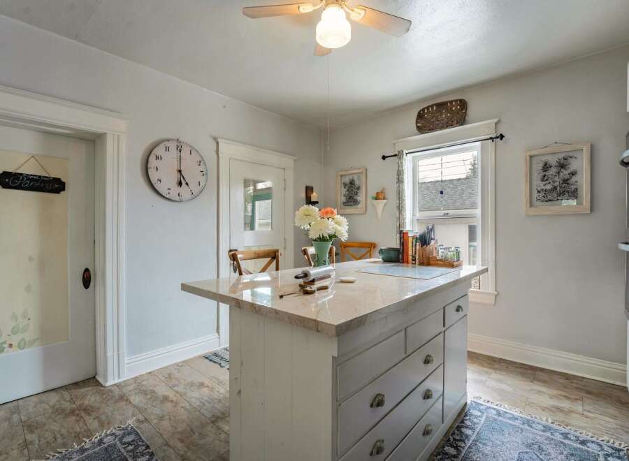 Step into this charming kitchen, featuring a stylish island with ample storage and a beautiful marble countertop.