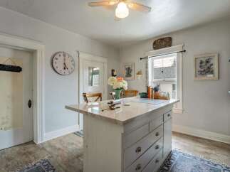 Step into this charming kitchen, featuring a stylish island with ample storage and a beautiful marble countertop.