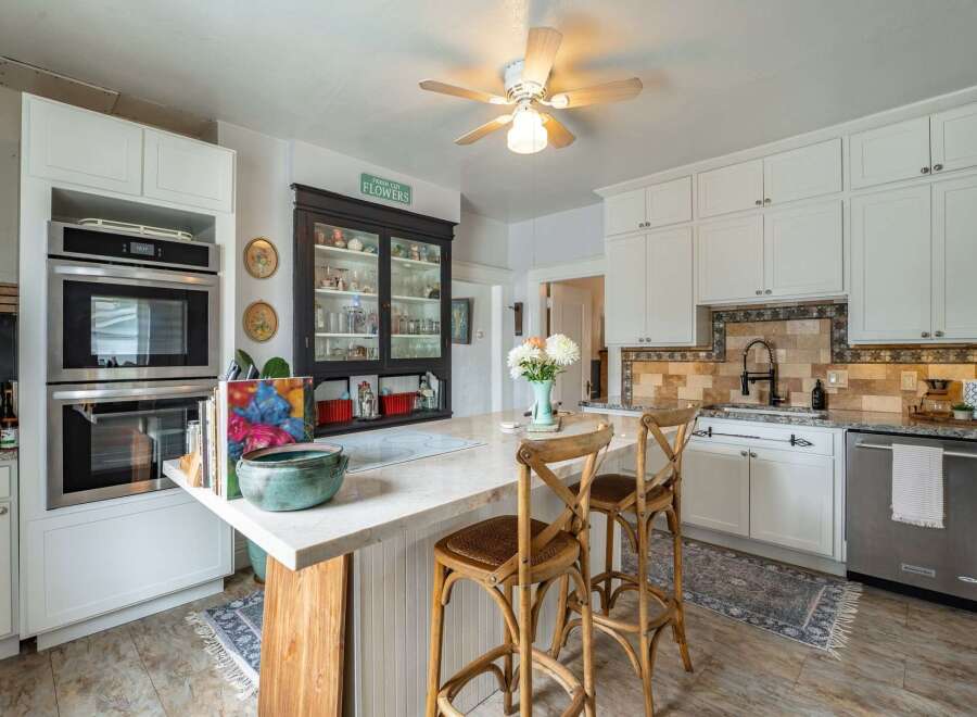 Step into this charming kitchen, featuring a stylish island with seating, perfect for casual dining and entertaining.