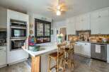 Step into this charming kitchen, featuring a stylish island with seating, perfect for casual dining and entertaining.