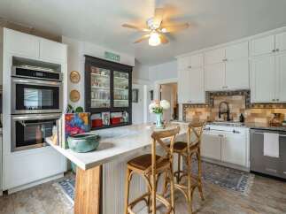 Step into this charming kitchen, featuring a stylish island with seating, perfect for casual dining and entertaining.