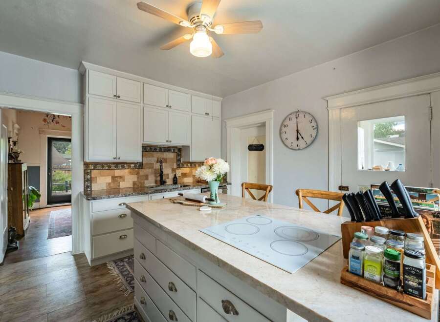 Step into this charming kitchen, featuring a spacious island with a modern cooktop, perfect for culinary creations.