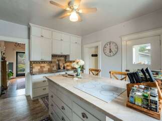 Step into this charming kitchen, featuring a spacious island with a modern cooktop, perfect for culinary creations.