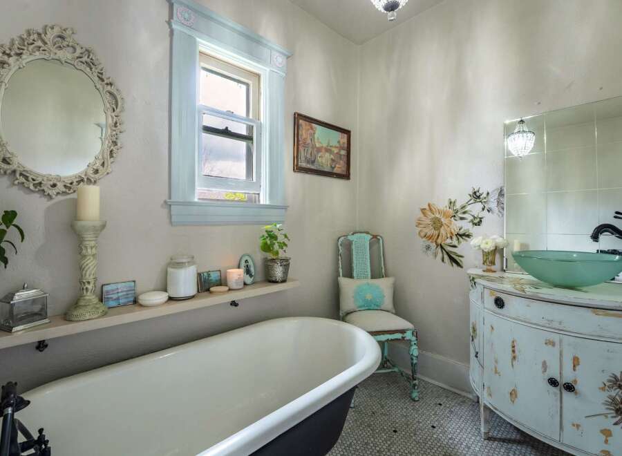 Step into a charming bathroom retreat! This space features a clawfoot tub, a stylish vanity, and a decorative mirror, creating a spa-like ambiance.
