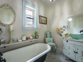 Step into a charming bathroom retreat! This space features a clawfoot tub, a stylish vanity, and a decorative mirror, creating a spa-like ambiance.