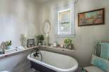 This charming bathroom features a clawfoot tub, creating a vintage and relaxing atmosphere.