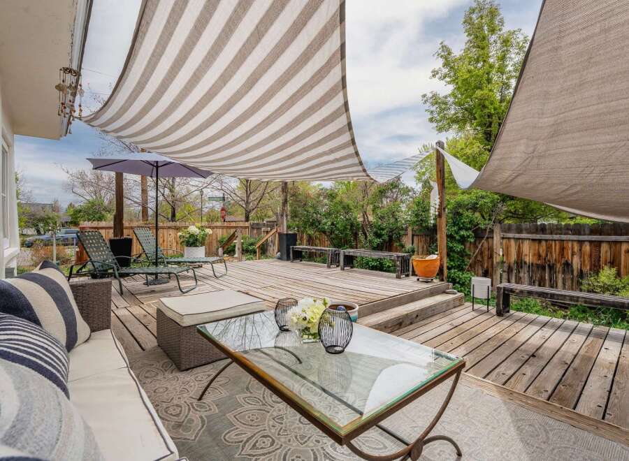 Enjoy outdoor living at its finest in this stunning property! This home features a beautifully designed deck with a stylish striped canopy, perfect for relaxing or entertaining.