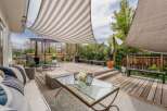 Enjoy outdoor living at its finest in this stunning property! This home features a beautifully designed deck with a stylish striped canopy, perfect for relaxing or entertaining.