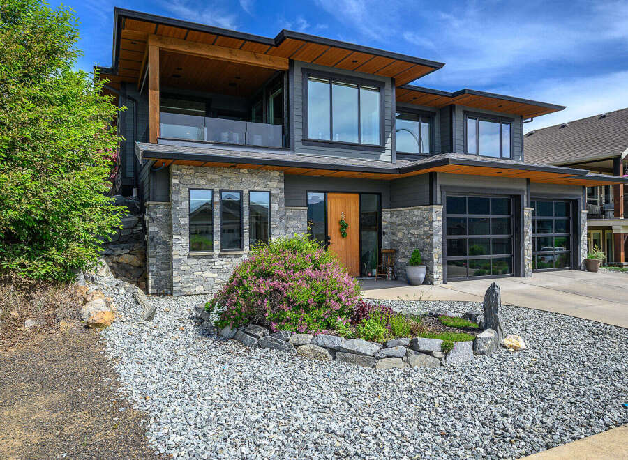 This stunning modern home boasts a beautiful exterior with a combination of stone and wood accents.