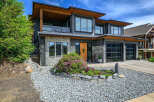 This stunning modern home boasts a beautiful exterior with a combination of stone and wood accents.